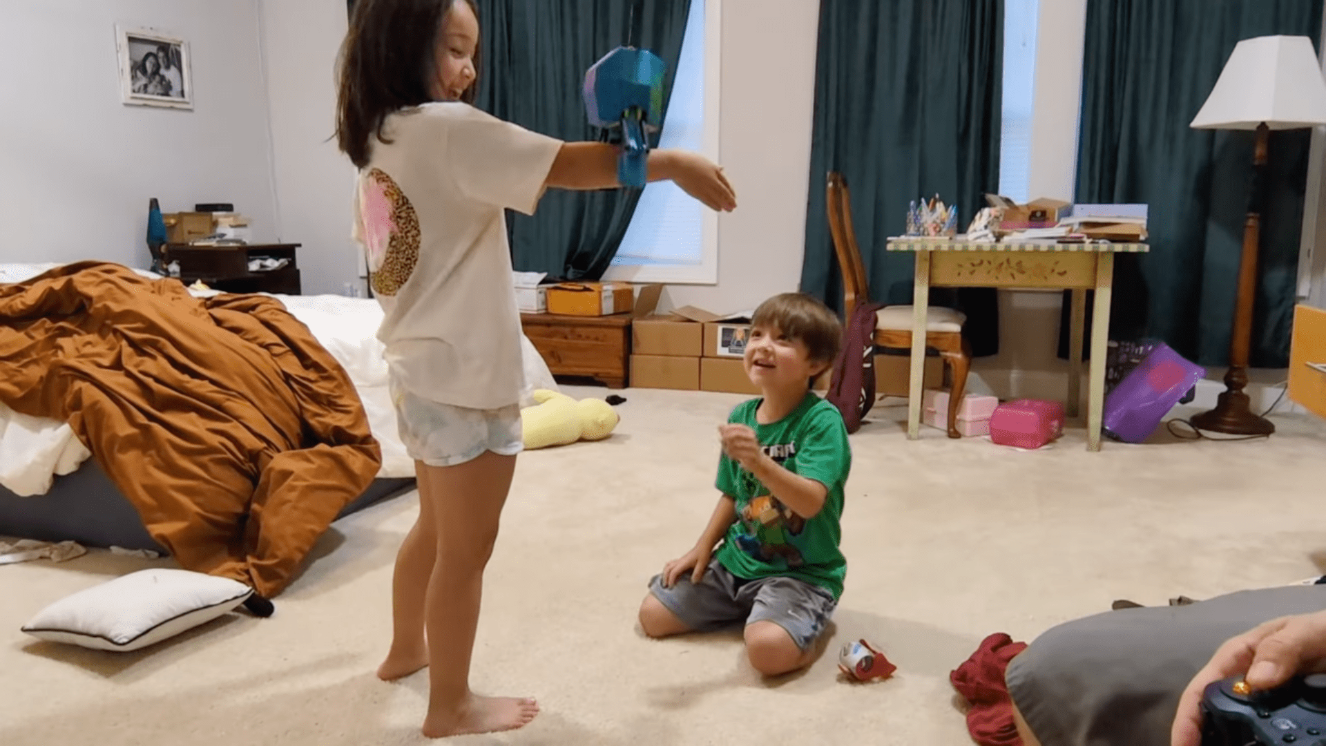 kids playing with a suspended, laundry-grabbing robot head